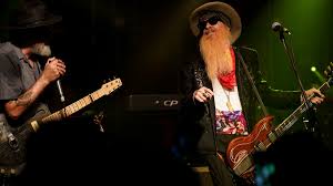 Billy gibbons, un señor con barba larga, tocando la guitarra